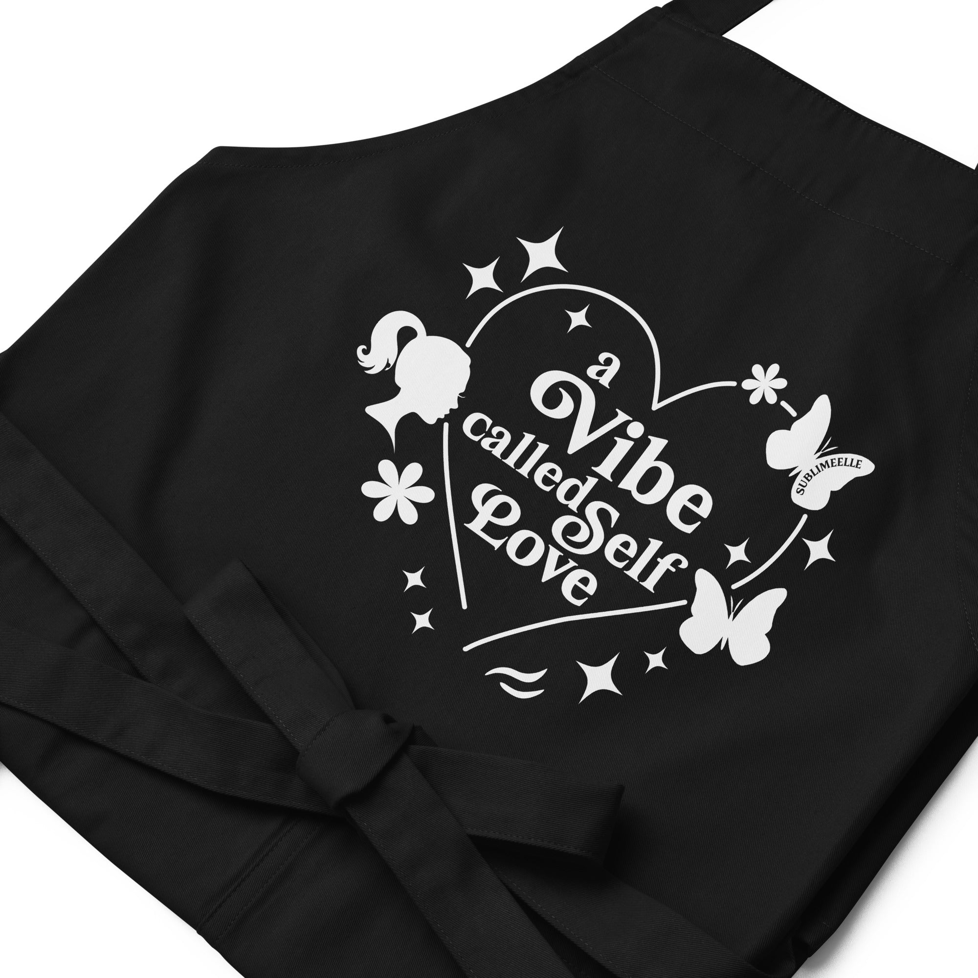 Close-up of black apron showing self-love design and attached strings, front view, kitchen accessory- SublimeElle Self - Love