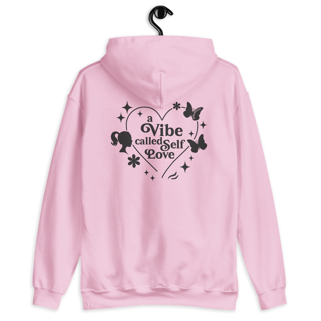 Pastel pink hoodie shown from the back with a design and printed text ‘a vibe called self-love’. Cozy self care and self love sweatshirt for confidence, healing and personal growth.